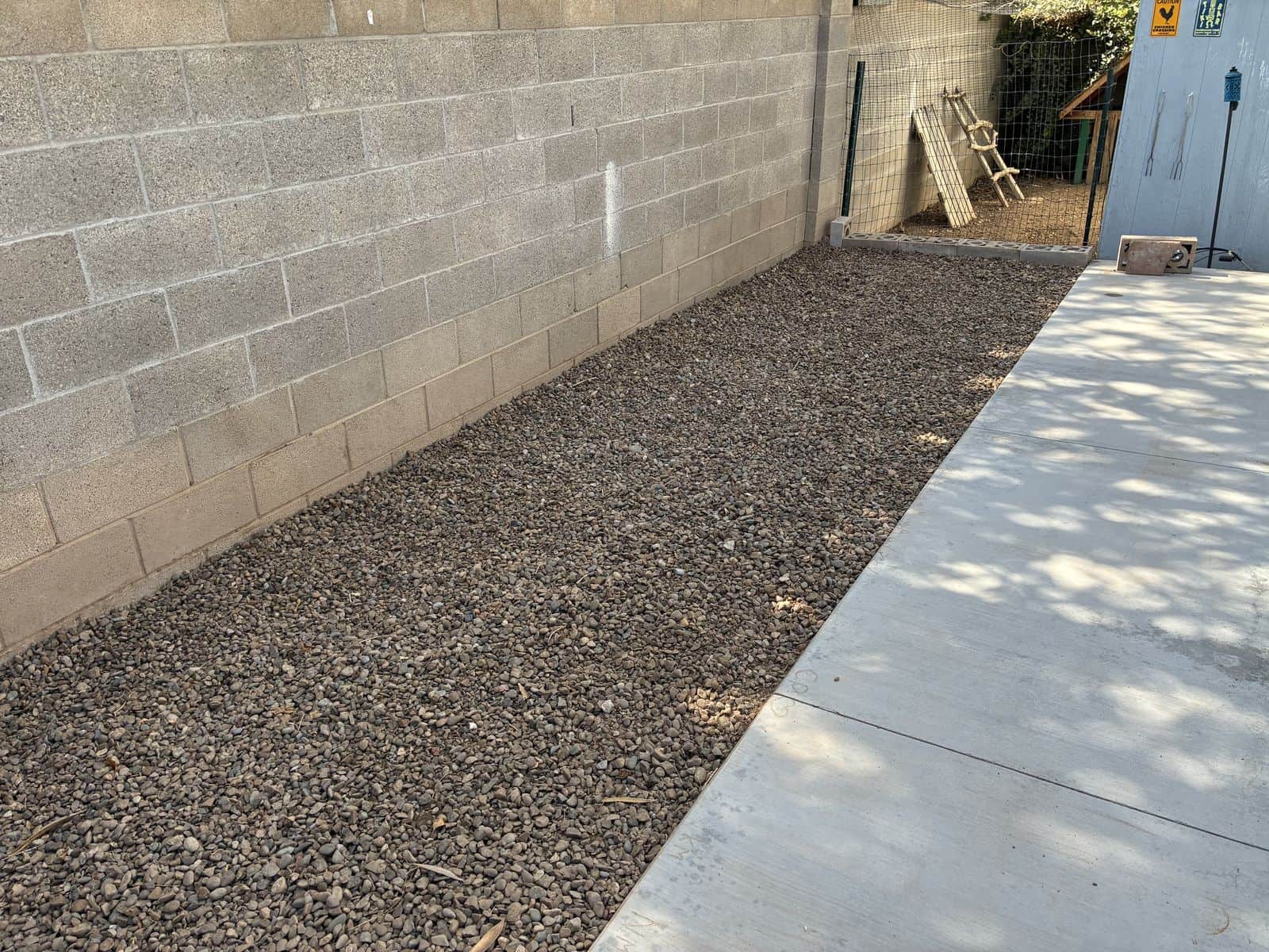 Freshly installed gravel bed along a block wall