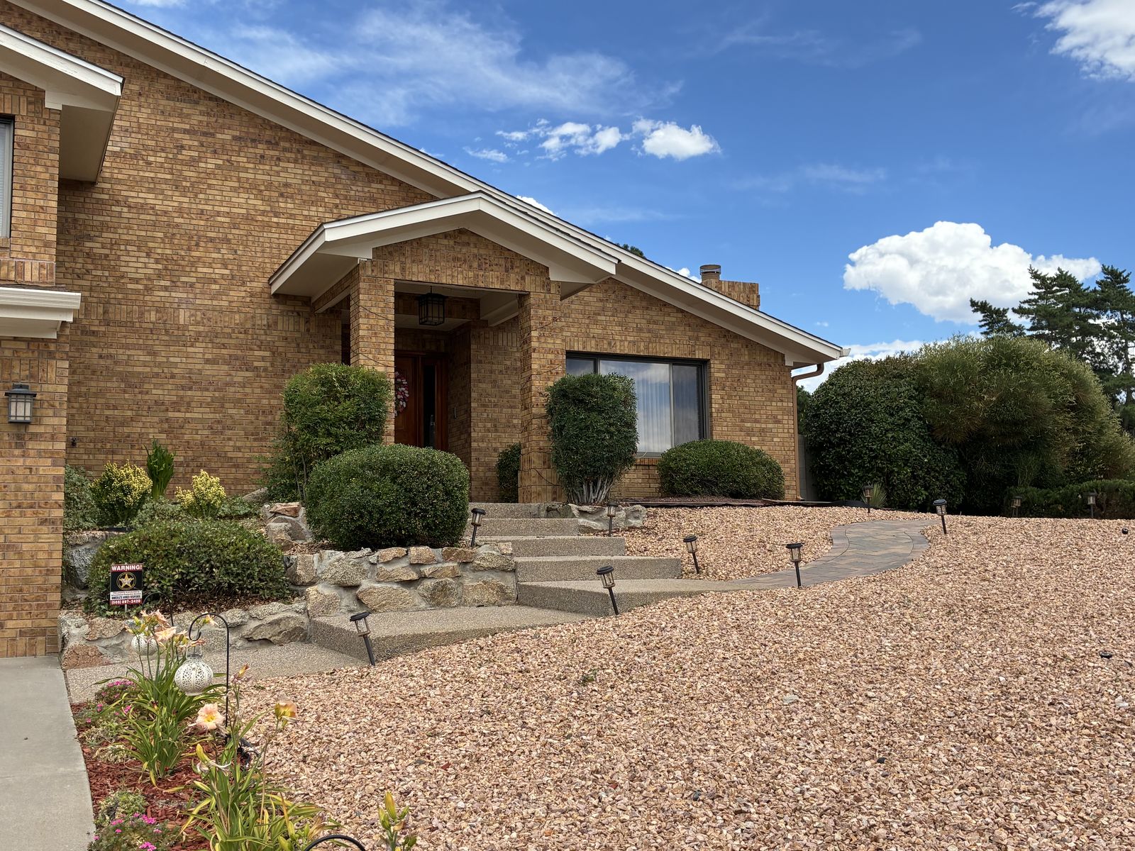 Front yard xeriscape with paver path and rock beds